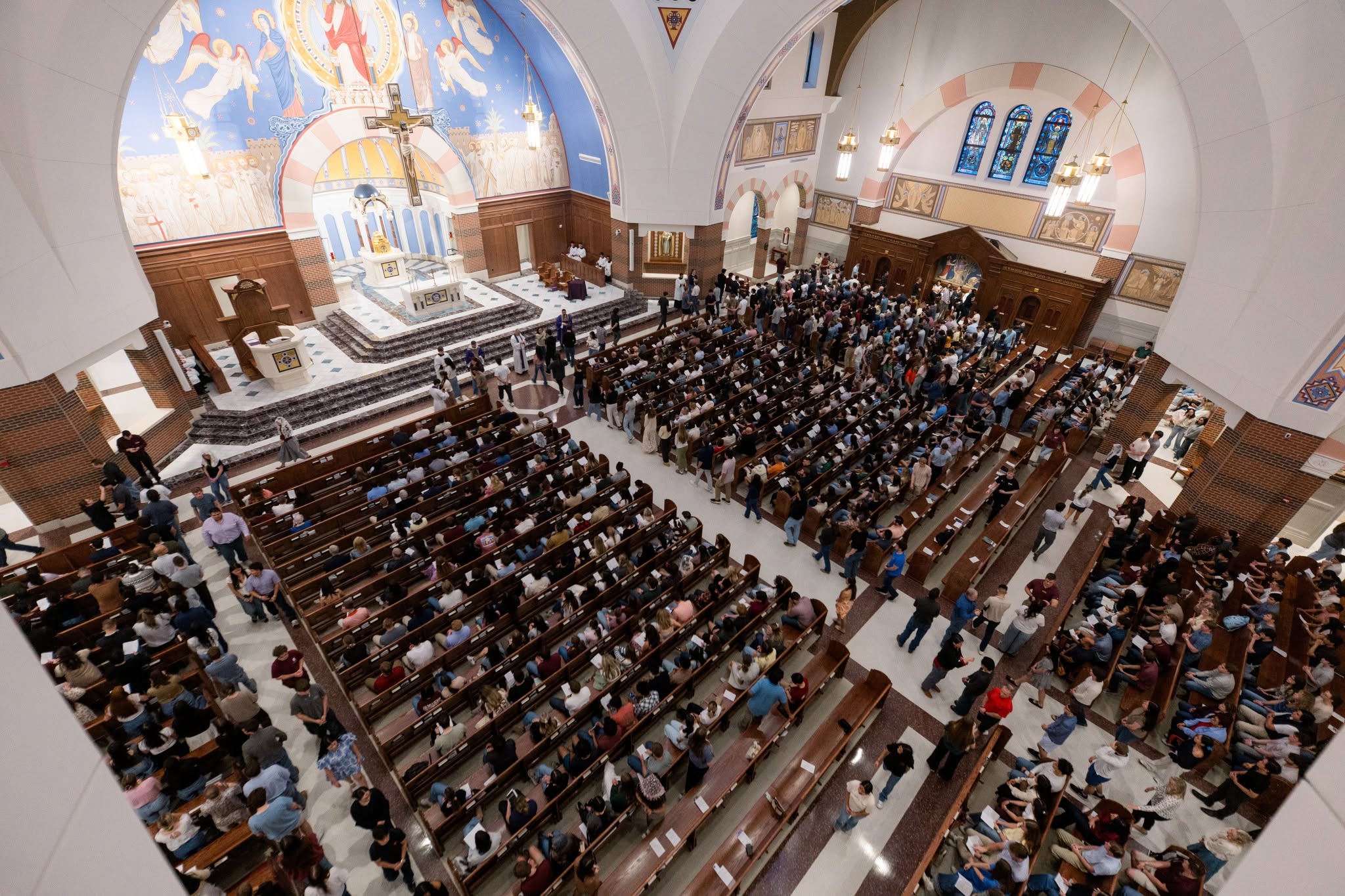 Students filling the pews and aisles inside St. Mary's Catholic Center in College Station